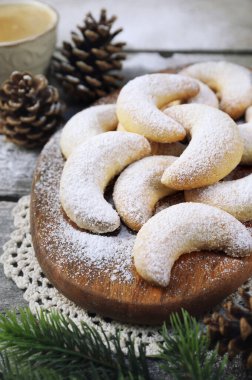 Vanillekipfer cookies. Amanda crescents Christmas cookies, powdered sugar dressing, cup of freshly brewed coffee,  new year decoration on wooden gray background