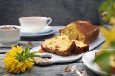 Yaz tatlısı. Kuru üzümlü kek, bir fincan çay ve bir buket fındık, ahşap arka planda kırsal stil.