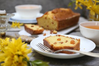 Yaz tatlısı. Kuru üzümlü kek, iki fincan çay ve bir buket fındık, ahşap arka planda kırsal stil.