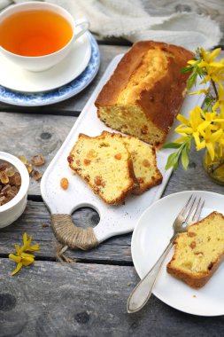 Yaz tatlısı. Kuru üzümlü kek, bir fincan çay ve bir buket fındık, ahşap arka planda kırsal stil.