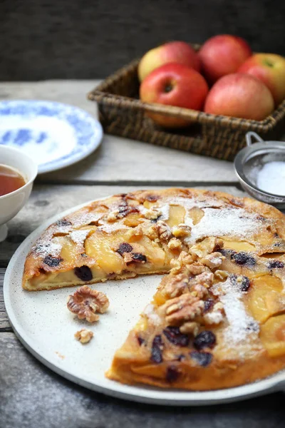 French cuisine. Matefaim. Sweet Apple Pancake with dried cranberries and walnuts, for breakfast on wooden background