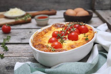 Ahşap arka planda seramik fırın kaplamalı peynirli çan biberi kapsülü (veya graten) domatesleri