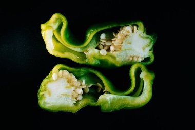 Dilimlenmiş yeşil çan biberi ve tohumlar. Siyah Arkaplan Üzerine Taze İç Dokuların Yakın Çekim Makrosu