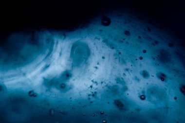 Yüzen hava kabarcıkları ve yumuşak eğimlerle mavi sualtı arka planı rüya gibi su dokusunu yaratıyor.