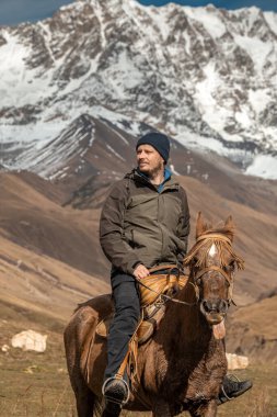 Georgia 'nın Svanetia bölgesindeki karlı dağlarda at binerken..