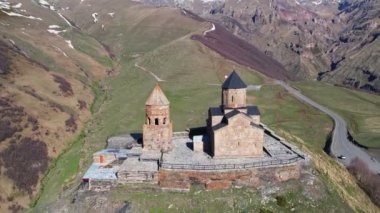Gergeti Trinity Kilisesi 'nin, dağın üzerinden ağır sis bulutları akan hava aracı görüntüsü. Stepantsminda, Georgia yakınlarındaki karlı zirvelerin güzel dağ manzarası..