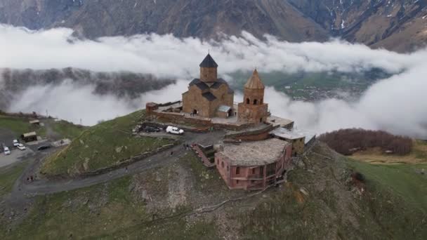 Vista Aérea Drone Igreja Trindade Gergeti Com Nuvens Névoa Pesada — Vídeo de Stock