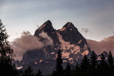 Ushba dağının bulutlu ve yeşil ormanlı havadan görünüşü. Kafkas Dağları, Gürcistan 'ın Svaneti bölgesi.