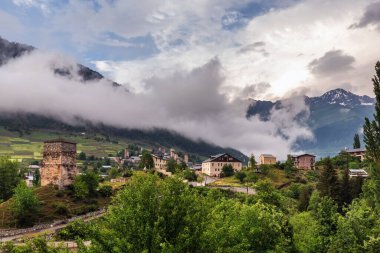 Arka planda tipik kule evleri ve sisli dağları olan Mestia köyü. Yukarı Svaneti, Georgia.