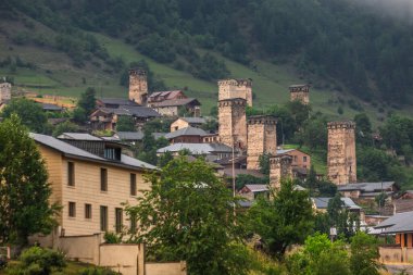 Arka planda tipik kule evleri ve sisli dağları olan Mestia köyü. Yukarı Svaneti, Georgia.