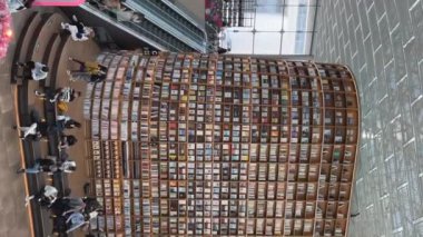 Starfield Kütüphanesi 'nin içeriden görünüşü. Kalabalık, resimli kitaplıklar ve kurulumlarla dekore edilmiş zengin iç mekanlarda geziyor. Dikey çekim. Seul, Güney Kore - 21 Mart 2023.