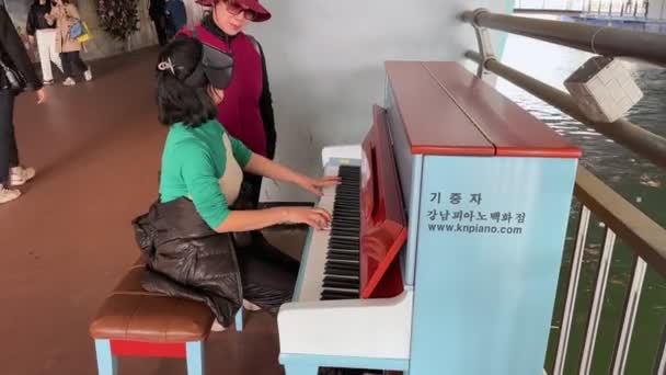 通りのピアニストが韓国ソウルの公園でピアノを演奏する 韓国ソウル 2023年3月21日 — ストック動画
