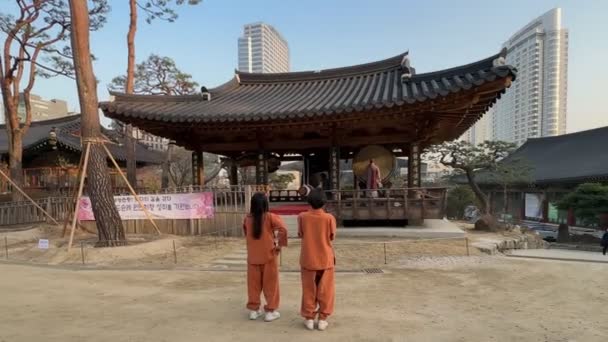 仏教僧が韓国ソウルの奉恩寺で大鼓を打つ ソウル江南の建物の森に位置しています 韓国ソウル 2023年3月21日 — ストック動画