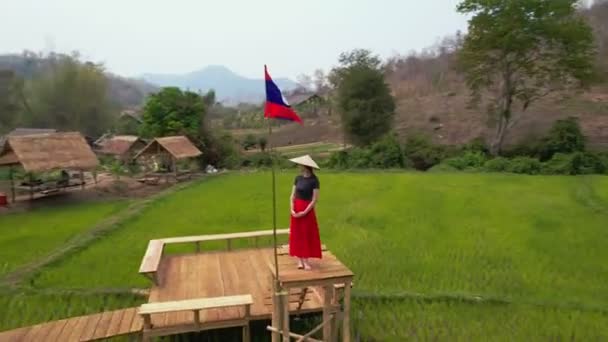 Female Stands Wooden Bridge Green Rice Field Laos Flag Pole — Stock Video