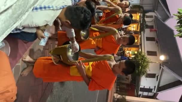 伝統的な神聖な施しの儀式で施しのボウルを持つ僧侶 地元の人々や観光客は ラオスのルアンパバーンにある仏教の僧侶のボウルに食べ物を入れました ラオスのビエンチャン 2023年3月4日 — ストック動画