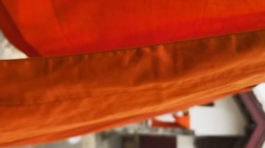 Budist rahiplerin cüppeleri yıkandıktan sonra kurumaya bırakılır. Luang Prabang, Laos 'taki tapınakta kurutmak için asılan keşiş cüppeleri. Turuncu kumaş..