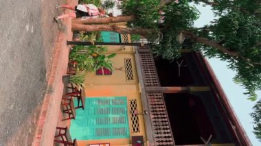 Luang Prabang 'ın eski caddelerinde, Luang Prabang, Laos' taki geleneksel tarz evler ve elektrik kablolarıyla genç bir bayan turist yürüyor. Tarihi sömürge Fransız mimarisi.
