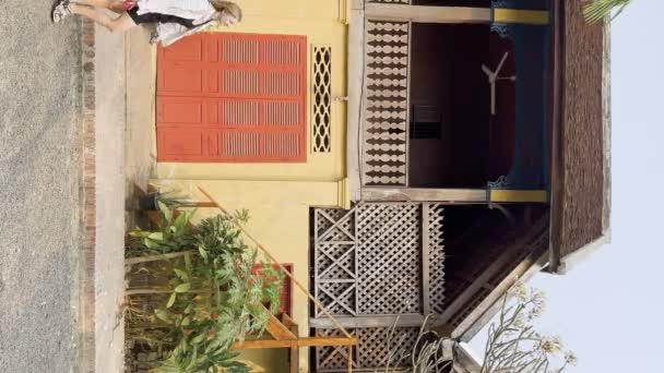 若い女性観光客がルアンパバーンの古い通りを歩き ラオス ルアンパバーンの多くの電源ケーブルを備えています フランスの歴史的建造物 — ストック動画