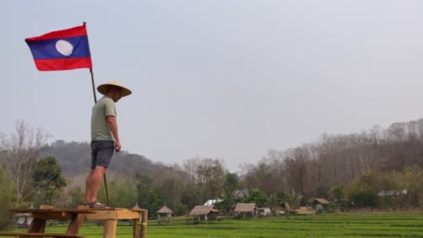 Mężczyzna Stoi Drewnianym Moście Nad Zielonym Ryżem Nosi Azjatycki Stożkowy — Wideo stockowe