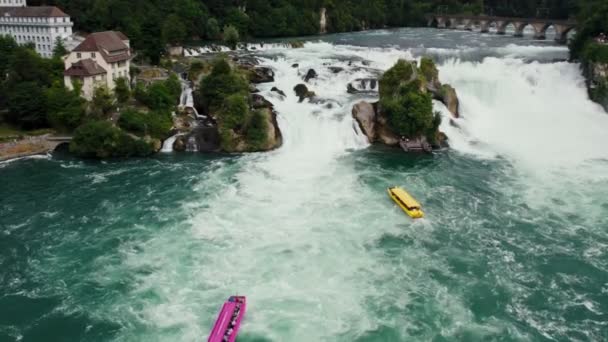 粉红船巡航在莱茵河瀑布 莱茵河中天然瀑布的空中美丽镜头 无人机飞过房屋 瑞士沙夫豪森 — 图库视频影像