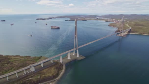 在符拉迪沃斯托克的东博斯普鲁斯海峡上俯瞰俄罗斯大桥 货船在水里航行 — 图库视频影像