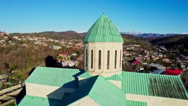 春の街並みを背景に クチジのバグダル大聖堂の再建された建物の空中観察 中世ジョージア建築の傑作 — ストック動画