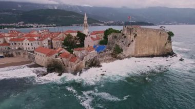 Kırmızı çatıları ve kilise çan kuleleri olan eski ortaçağ taştan evleri. Budva, Karadağ 'ın turizm merkezi ve bir yaz tatili beldesi. Karadağ 'da hava aracı şehir manzarası.