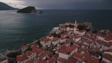 Kırmızı çatıları ve kilise çan kuleleri olan eski ortaçağ taştan evleri. Budva, Karadağ 'ın turizm merkezi ve bir yaz tatili beldesi. Karadağ 'da hava aracı şehir manzarası.