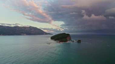 Budva kenti yakınlarındaki güzel Sveti Nikola Adası 'nın insansız hava aracı manzarası, Adriyatik Denizi, Karadağ' da güzel bir yaz sabahında gün batımı.