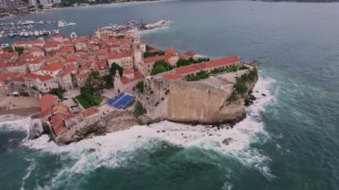 Kırmızı çatıları ve kilise çan kuleleri olan eski ortaçağ taştan evleri. Budva, Karadağ 'ın turizm merkezi ve bir yaz tatili beldesi. Karadağ 'da hava aracı şehir manzarası.