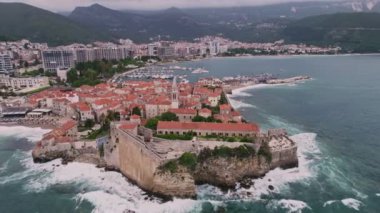 Kırmızı çatıları ve kilise çan kuleleri olan eski ortaçağ taştan evleri. Budva, Karadağ 'ın turizm merkezi ve bir yaz tatili beldesi. Karadağ 'da hava aracı şehir manzarası.