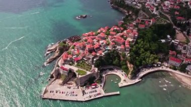 Yaz sezonu boyunca Karadağ 'ın güzel Ulcinj kentinin üzerinde uçan insansız hava aracı. Eski taştan evler ve Adriyatik Denizi sahillerinde yüzen insanlar.. 