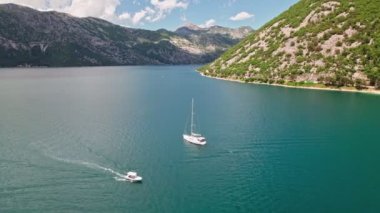 Karadağ 'ın Perast kentindeki Saint George Adası yakınındaki yat. Kotor Bay Montenegro, Avrupa 'daki Rock Adası' nın Leydisi ve Perast Kilisesi. 4K Drone Görüntüsü.