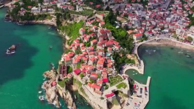 Yaz sezonu boyunca Karadağ 'ın güzel Ulcinj kentinin üzerinde uçan insansız hava aracı. Eski taştan evler ve Adriyatik Denizi sahillerinde yüzen insanlar.. 