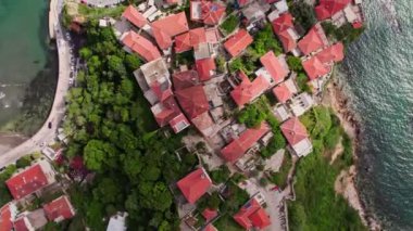 Yaz sezonu boyunca Karadağ 'ın güzel Ulcinj kentinin üzerinde uçan insansız hava aracı. Eski taştan evler ve Adriyatik Denizi sahillerinde yüzen insanlar.. 