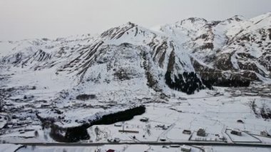 İnsansız hava aracı görüntüleri. Dağ vadisi. Gürcistan 'ın Kazbegi vadisinde karla kaplı dağlar. 