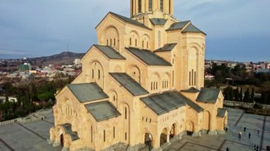 Kutsal Tiflis Trinity Katedrali, Gürcistan 'ın dış görünüşü katedralin eşsiz mimarisini gösteriyor. Merdivenlerde yürüyen insanlar ve gökyüzünde bulutlar var.. 