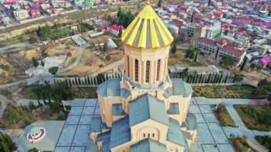 Kutsal Tiflis Trinity Katedrali, Gürcistan 'ın dış görünüşü katedralin eşsiz mimarisini gösteriyor. Merdivenlerde yürüyen insanlar ve gökyüzünde bulutlar var.. 