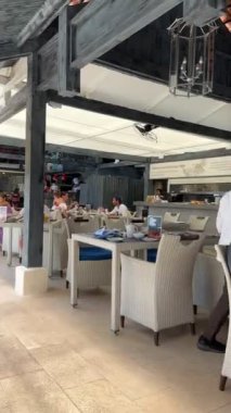  Koh Samui, Tayland 'da kumlu bir sahilde sahil restoranı. Neşeli insanlar otelde kahvaltıdan hoşlanırlar. Koh Samui - 21 Mayıs 2023