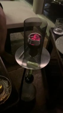 Nargileden çıkan dumanın yavaş çekim videosu. Kafasında yanan küplerle bir holiganın yakın çekimi..