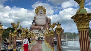 Wat Plai Laem Tapınağı 'nda kadın yürüyüşü. Koh Samui, Tayland' da Guanyin 'in çok kollu heykeli, canlı bir dini sanat. Koh Samui - 14 Ağustos, 2023.