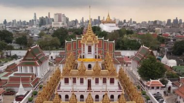 Wat Ratchanatdaram Worawihan Tapınağı 'nın ikonik Loha Prasat, karmaşık kuleler ve yavaş çekimde sıcak, zengin mimari güzelliği ile hava görüntüsü. Bangkok, Tayland - 07 Mayıs 2023