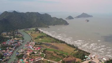 4K kireçtaşı kayaları, ormanlar ve Tayland 'daki Phraya Nakhon Mağarası yakınlarında hava temizleyicisi olan bir karides çiftliği görüntüsü. Uluslararası pazara sürekli büyüyen su ürünleri ihraç edilmektedir..