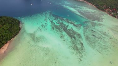Koh Phi Phi, Krabi Tayland 'da kristal berrak turkuaz su. Phi Phi Don adası güneşli bir günde insansız hava aracından. 4K videosu yavaş çekimde.