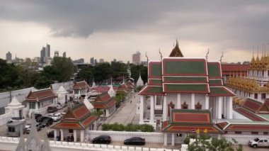 Bangkok Tayland 'daki Wat Ratchanatdaram Worawihan tapınağının havadan görünüşü. İkonik Loha Prasat 'ın çarpıcı görüntüleriyle tapınak, karmaşık kuleler ve zengin mimari güzelliği yavaş çekimde sıcak 4K