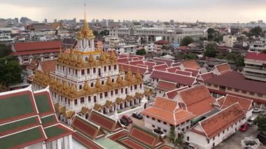 Bangkok Tayland 'daki Wat Ratchanatdaram Worawihan tapınağının havadan görünüşü. İkonik Loha Prasat 'ın çarpıcı görüntüleriyle tapınak, karmaşık kuleler ve zengin mimari güzelliği yavaş çekimde sıcak 4K
