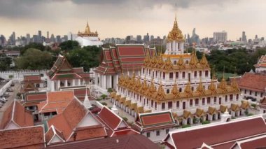 Bangkok Tayland 'daki Wat Ratchanatdaram Worawihan tapınağının havadan görünüşü. İkonik Loha Prasat 'ın çarpıcı görüntüleriyle tapınak, karmaşık kuleler ve zengin mimari güzelliği yavaş çekimde sıcak 4K