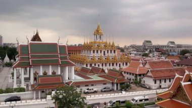 Bangkok Tayland 'daki Wat Ratchanatdaram Worawihan tapınağının havadan görünüşü. İkonik Loha Prasat 'ın çarpıcı görüntüleriyle tapınak, karmaşık kuleler ve zengin mimari güzelliği yavaş çekimde sıcak 4K