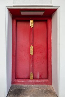 Bangkok, Tayland 'daki ünlü tapınakta bulunan, karmaşık altın kakmalı ahşap bir kapıya yakın plan.