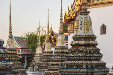 Wat Pho 'daki büyük pagoda Buda tapınakları. Mavi gökyüzüne karşı işlenmiş karmaşık süslemeler ve pırıl pırıl altınlarla süslenmiş. Bangkok, Tayland.